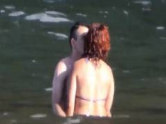 Horny couple having some fun in the water at the beach