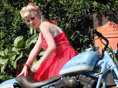 Cute blonde enjoys posing next to a bike