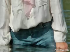 Clothed slut sensually touching wet body in the lake