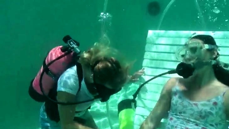 Scuba woman tied in chair underwater